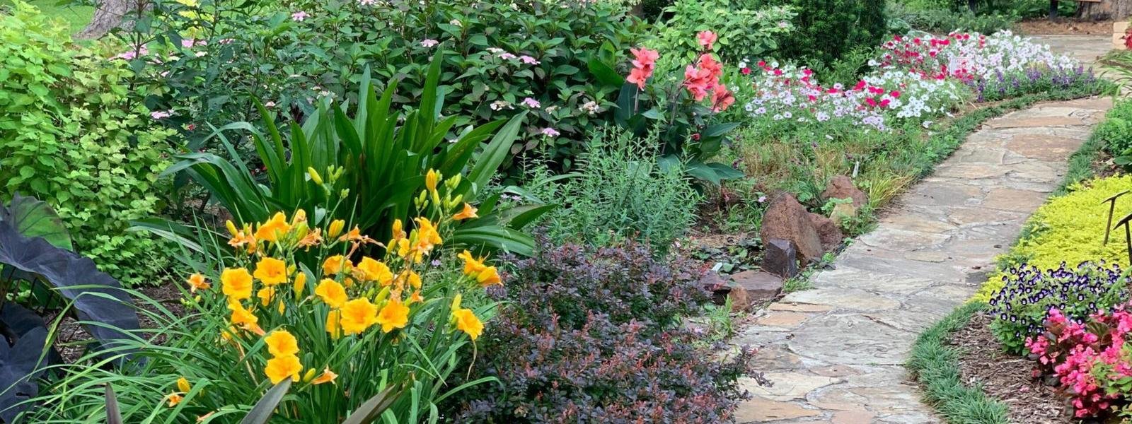 Flower beds in full bloom beside a garden path