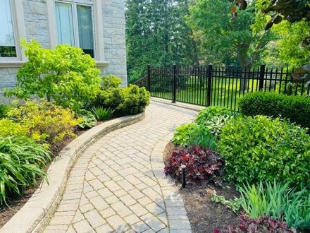 Weed-free paved path running between planted beds
