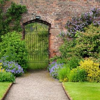 Planted borders either side of a brick garden archway